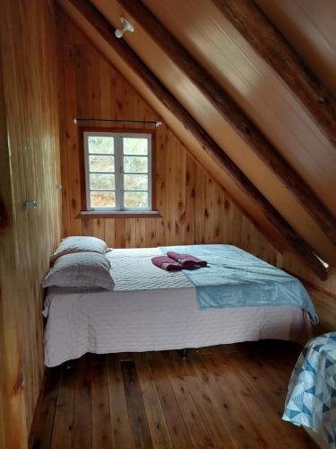 a bedroom with a bed in a wooden cabin at Chale Primavera in Benedito Novo