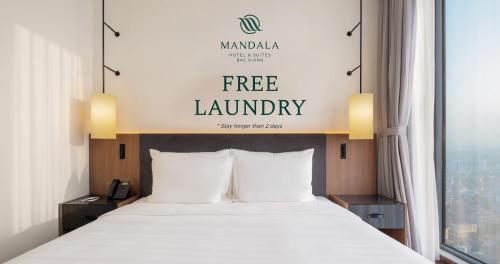 a bed in a hotel room with a free laundry sign at Mandala Hotel & Suites Bac Giang in Bắc Giang