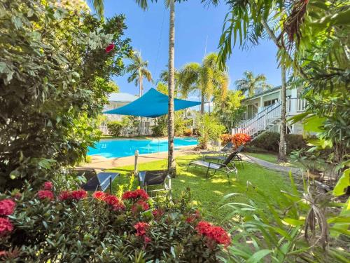 a resort yard with a swimming pool and palm trees at Whispering Palms at Mango House in Airlie Beach