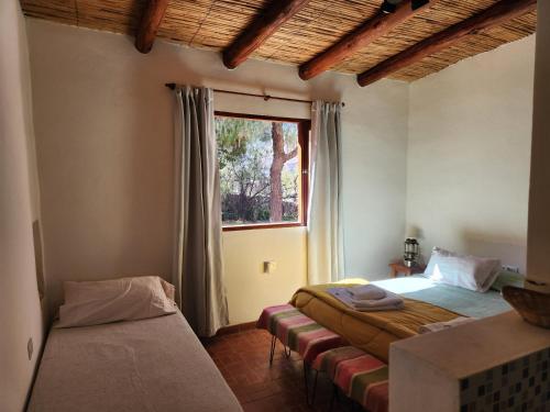 a bedroom with two beds and a window at Vivir en Maimará in Maimará