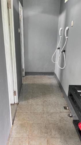 a hallway with hangers on the wall and a tile floor at D Cottage Sabin in Punten