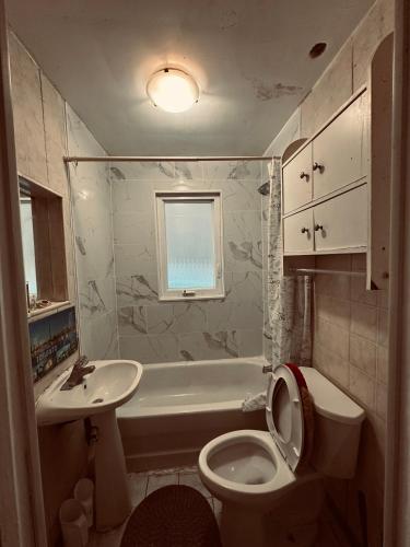 a bathroom with a toilet and a sink and a tub at Space Share Accommodation East York Budget Friendly in Toronto