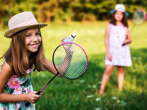 una bambina che tiene in mano una bottiglia d'acqua e una racchetta da tennis di ibis Styles Aix les Bains Domaine de Marlioz ad Aix-les-Bains