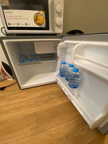 an open refrigerator with bottles of water in it at SridaHouse#Near Central Festival Hatyai in Hat Yai