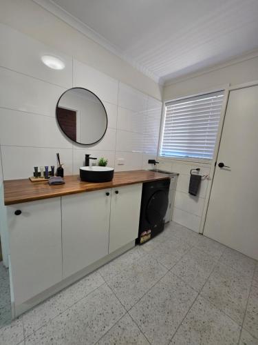 a bathroom with a sink and a mirror on a counter at LBarza 1BR CBD Self Contained Apartment in Shepparton