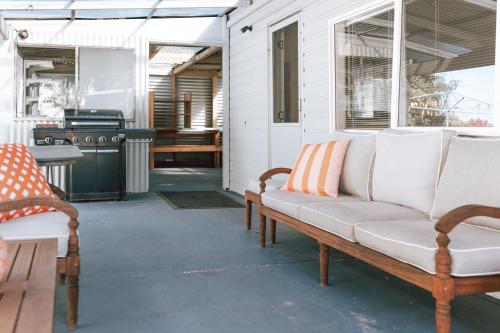 a porch with a couch and a stove at Mara House - Space for Everyone in St Helens