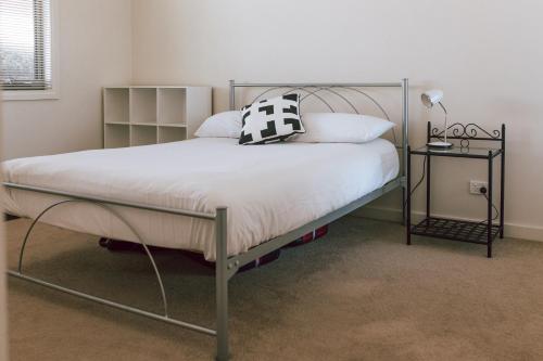 een bed met een metalen frame in een slaapkamer bij Mara House - Space for Everyone in St Helens
