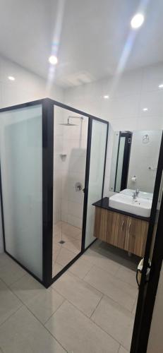 a bathroom with a shower and a sink at The Retreat Apartment in Nadi