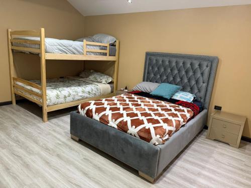 a bedroom with a bed and two bunk beds at Quinta Nallig in Gualaceo