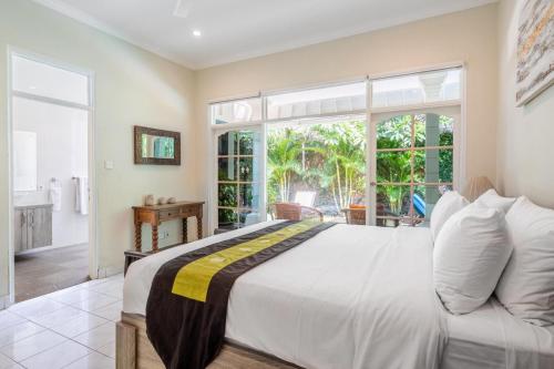 a bedroom with a large bed and a large window at Alinta Villa 1 - Spacious Sanctuary in Sanur