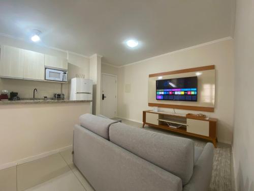 een woonkamer met een bank en een flatscreen-tv bij Apartamento no Centro em Poços de Caldas in Poços de Caldas