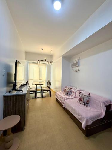 a bedroom with a bed and a table in it at 1 Bedroom Condo Unit at Centrio Tower in Cagayan de Oro
