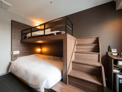 una camera con 2 letti a castello e un letto bianco di Super Hotel Premier JR Nara Eki a Nara