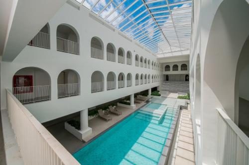 an indoor pool in a building with a skylight at Away Bangkok Riverside Kene in Bangkok