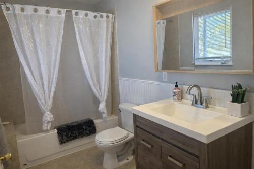 een badkamer met een wastafel, een toilet en een bad bij Tremont Hidden Treasure in East Orange