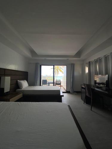 a hotel room with two beds and a window at Anaya Villas Resort in Bantayan Island