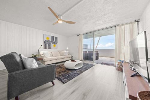 een woonkamer met een bank en een tv bij Beachfront Condo with Ocean View in Hauula