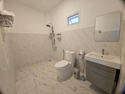 a white bathroom with a toilet and a sink at Doi Luang Vista Homestay in Ban Mae To