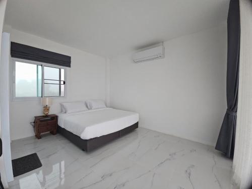 a white bedroom with a bed and a window at Doi Luang Vista Homestay in Ban Mae To