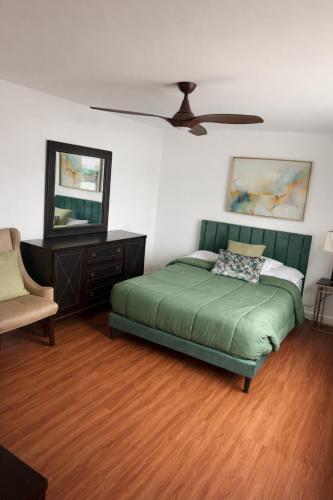 a bedroom with a green bed and a mirror at Tremont Hidden Treasure in East Orange