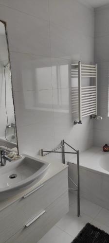a white bathroom with a sink and a mirror at Furadouro pine beach apartment in Ovar