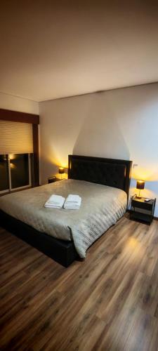 a bedroom with a bed with two towels on it at Furadouro pine beach apartment in Ovar