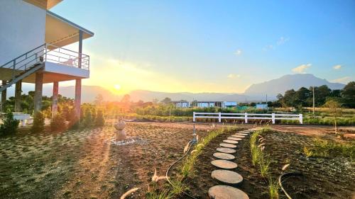 a building with a fence and a fountain in a yard at Doi Luang Vista Homestay