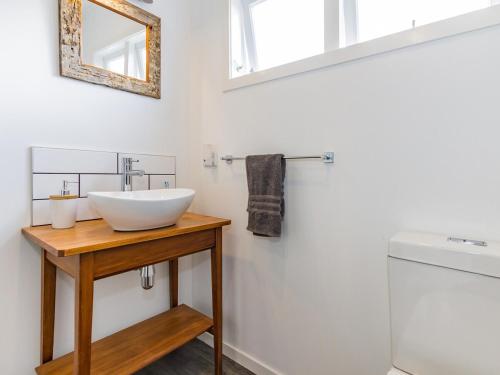 a bathroom with a white sink and a mirror at Aroha Cottage in Ohakune