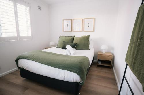 a bedroom with a bed with green and white sheets at Quiet Little Manly 1 bed - 3min walk Harbour & Beaches w Level Access in Sydney