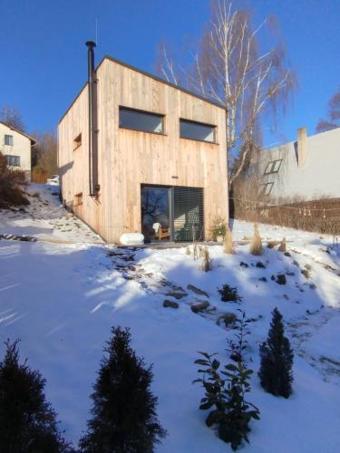 a wooden house in the snow in a yard at Chata Lipnice in Lipnice nad Sázavou