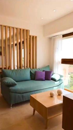 a living room with a blue couch and a coffee table at Villa Gesell departamento frente al mar in Villa Gesell