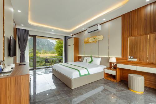 a bedroom with a bed and a desk and a television at Ruby Mountain View Resort Vang-vieng in Vang Vieng