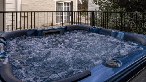 a hot tub filled with water in front of a fence at Original Beach Retreat in Surf Beach