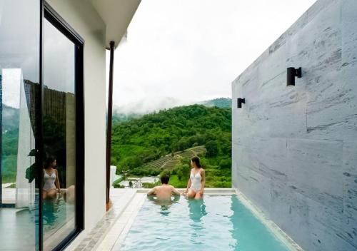 a group of people sitting in a swimming pool at Vianna Villas Chiangmai in Mae Rim