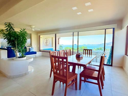 a dining room with a table and chairs with a view at Departamentos Frente al Mar en Ixtapa in Ixtapa