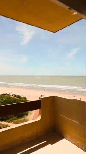 a view of the beach from the balcony of a building at Villa Gesell departamento frente al mar in Villa Gesell