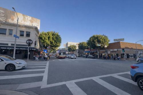 a busy city street with cars and a bus at The Art Nook Private Rooms on Hollywood Blvd in Los Angeles