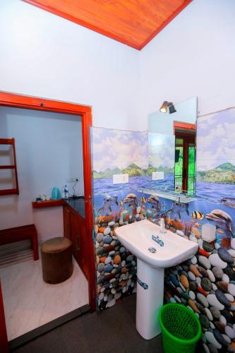 a bathroom with a sink and a rock wall at Forest Edge Villa in Ella