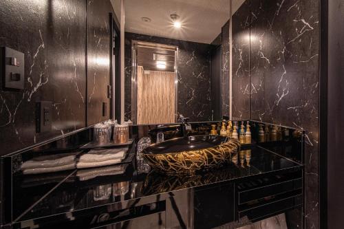 a black bathroom with a sink and a mirror at HOTEL FIVE -Adult Only- in Osaka