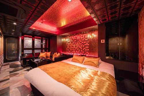 a bedroom with a large bed with red lighting at HOTEL FIVE -Adult Only- in Osaka