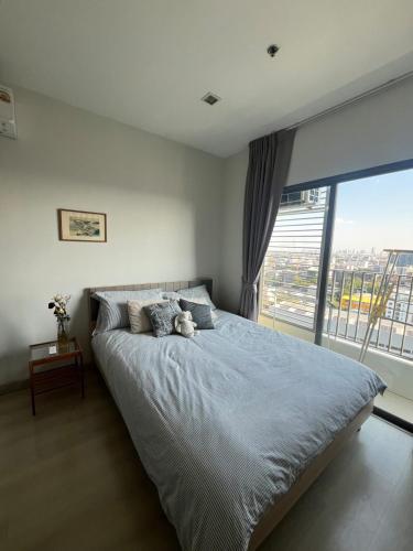 a bedroom with a bed with a teddy bear on it at Cozy Japandi Stay on Sukhumvit in Bangkok