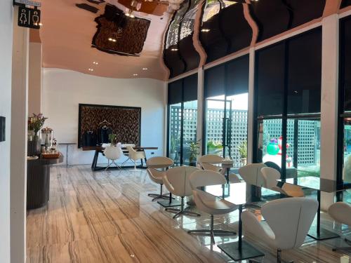 a room with chairs and tables and a fireplace at Hotel Le Naga in Sakon Nakhon