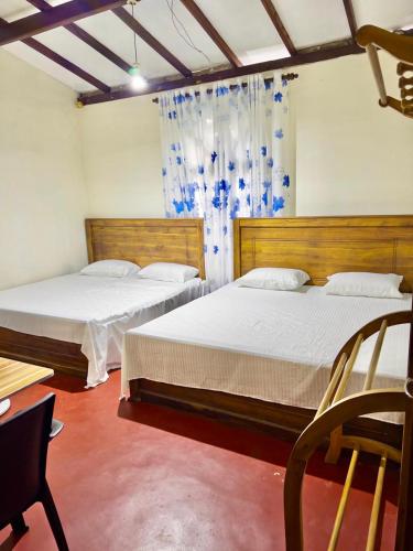 a bedroom with two beds and a window at Diyakalana Rest in Ginigathena