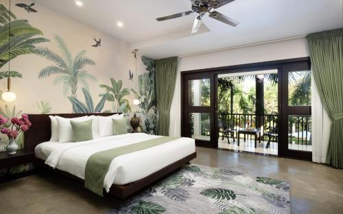 una camera da letto con un letto grande e un balcone di The Elephant a Siem Reap