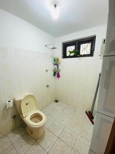 a bathroom with a toilet and a window at Open Sky Villa in Hikkaduwa