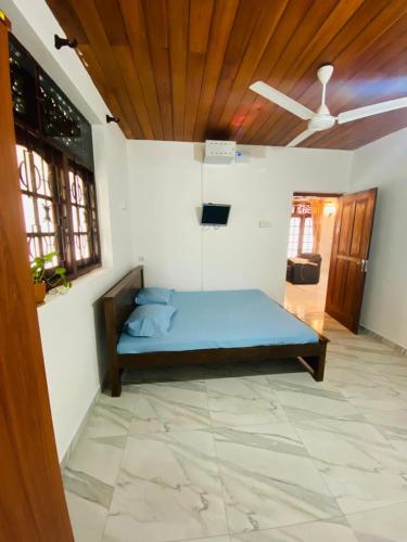 a bedroom with a blue bed in a room at Open Sky Villa in Hikkaduwa