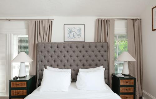 a bedroom with a bed with white pillows and two lamps at Norment Parry by The Wellborn in Orlando
