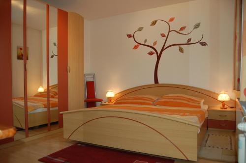 1 dormitorio con 1 cama con un árbol en la pared en Ferienwohnung Leeb, en Sirnitz