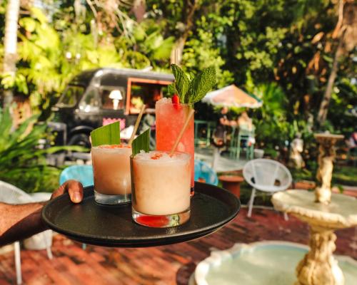 a person holding two cocktails on a tray at Norment Parry by The Wellborn in Orlando