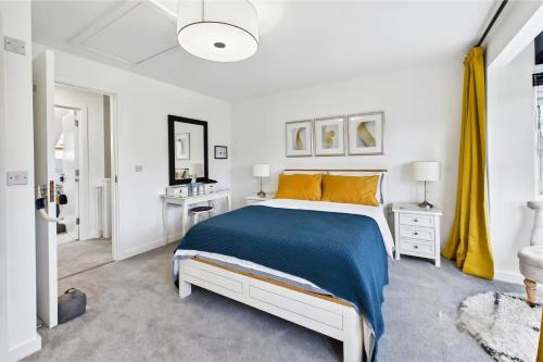 a white bedroom with a bed and a yellow curtain at 3 bed modern townhouse with self check in, sleeps 6, 35mins direct train to London Waterloo, zone 6 in Ewell